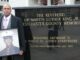 Kenneth Chamberlain Jr. holds a photo of his father when he served as a U.S. Marine. He is standing by a stature of Dr. Martin Luther King Jr. in front of the Westchester County Courthouse in White Plains, New York. (Courtesy of Kenneth Chamberlain Jr.) 