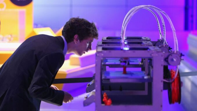 A technician checks on a 3D printer as it constructs a model human figure in the exhibition '3D: printing the future' in the Science Museum on October 8, 2013 in London, England. The exhibition, which opens to the public tomorrow, features over 600 3D printed objects ranging from: replacement organs, artworks, aircraft parts and a handgun. (Photo by Oli Scarff/Getty Images)