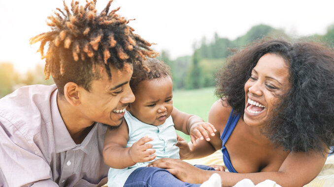 Happy African family enjoying a picnic sunny day outdoor - Mothe