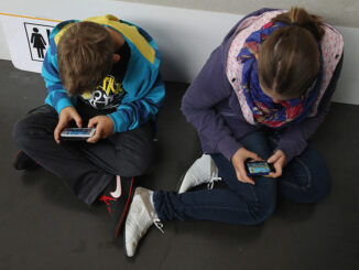 Children play video games on smartphones while attending a public event on September 22, 2012 in Ruesselsheim, Germany. (Photo by Sean Gallup/Getty Images)