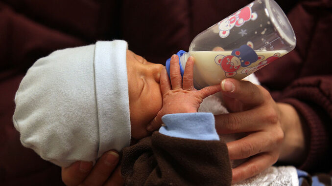 Diego Gomez drinks breast milk from a bottle during a newborn care class on February 23, 2010 in Aurora, Colorado. (Photo by John Moore/Getty Images)