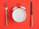 A table set with a fork and a knife including a plate as a clock. Intermittent fasting popular with celebrities is ineffective for shedding weight, according to new research. PEDAL TO THE STOCK/SWNS TALKER